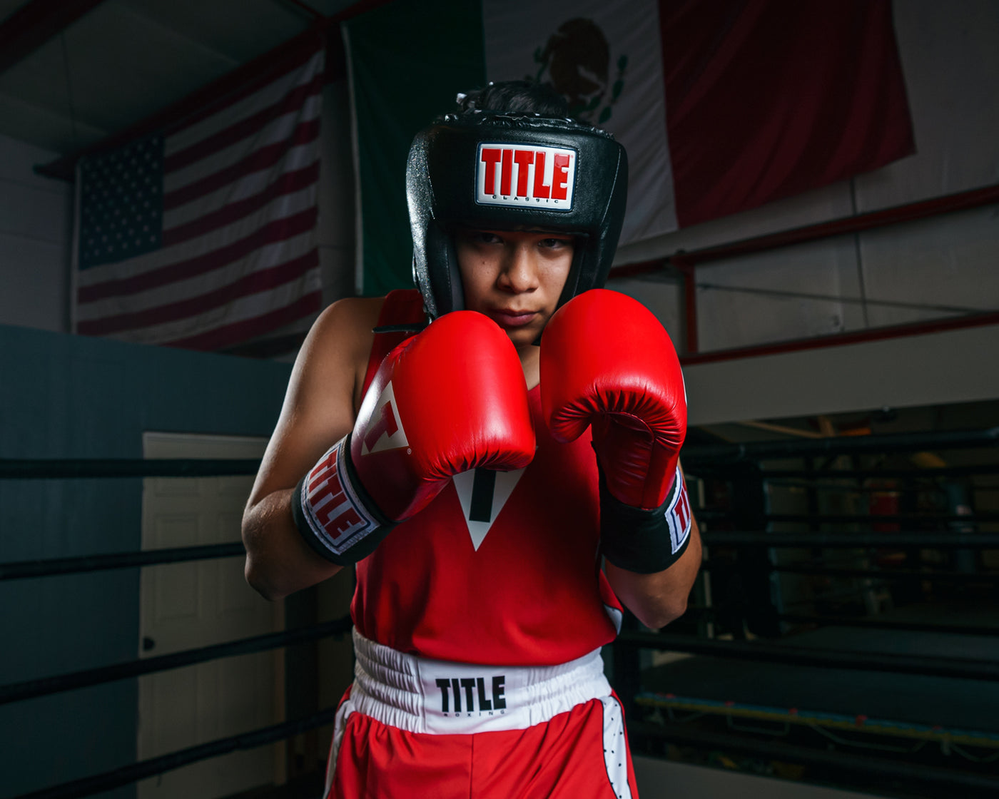 variant:black::TITLE Classic USA Boxing Competition Headgear- With Cheeks kid in ring hands up boxing pose