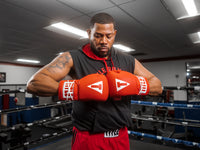 variant:red::TITLE Classic Leather Lace Training Gloves 2.0 guy in ring with hands together 
