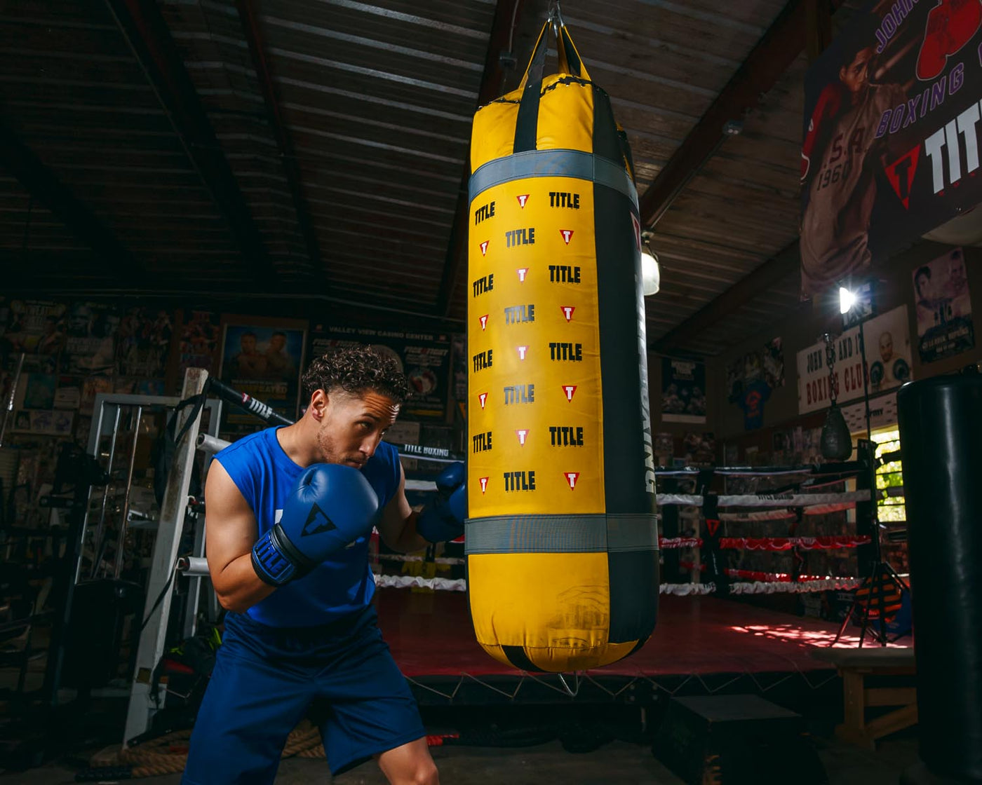 variant:blue/black::TITLE Boxing Dauntless Training Gloves alt guy hitting bag full bag