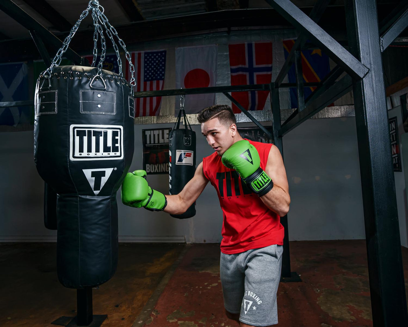 variant:green/black::TITLE Boxing Dauntless Training Gloves guy hitting bag