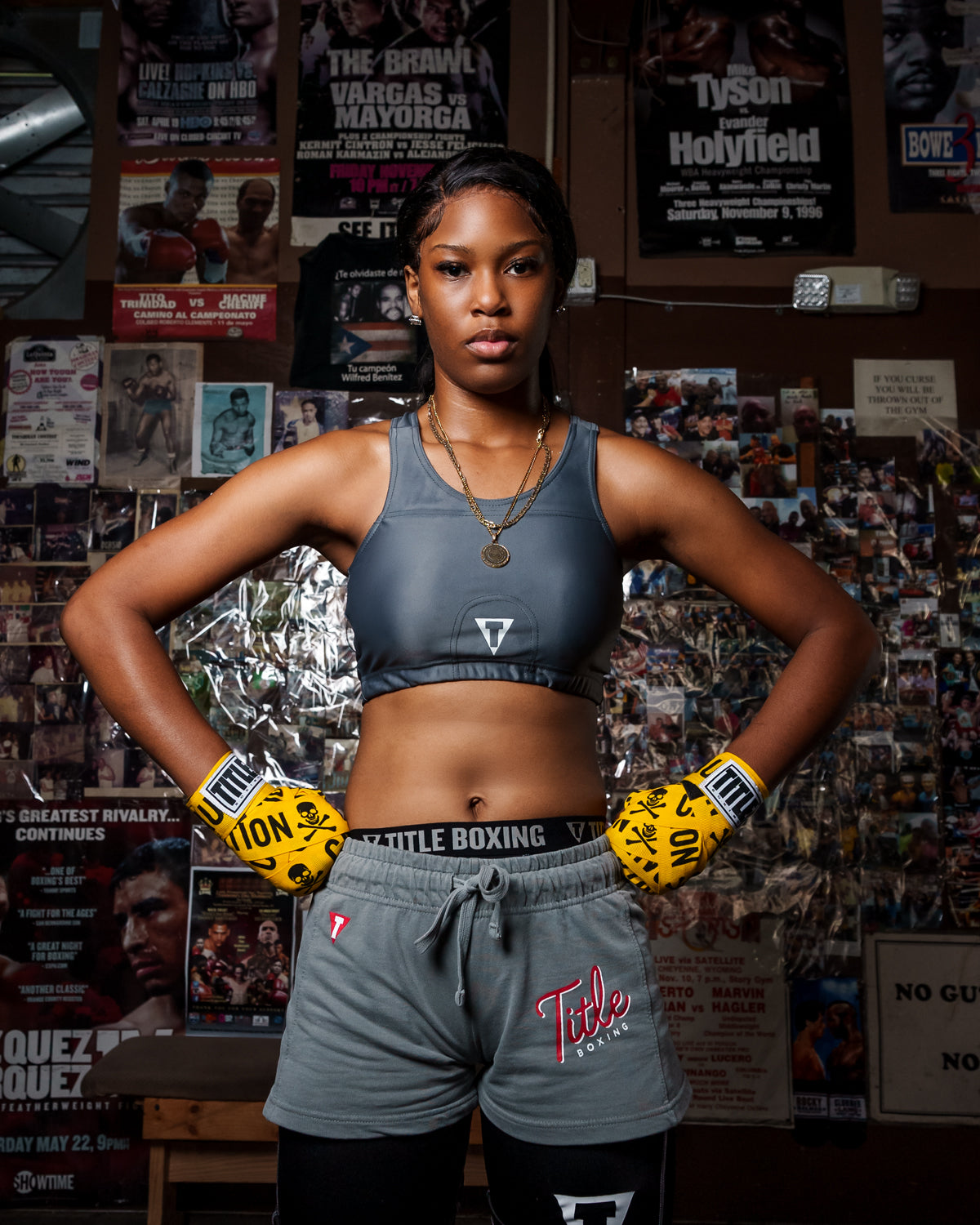 variant:Grey::TITLE Boxing Pro Compression Ascent Sports Bra girl infront of pictures