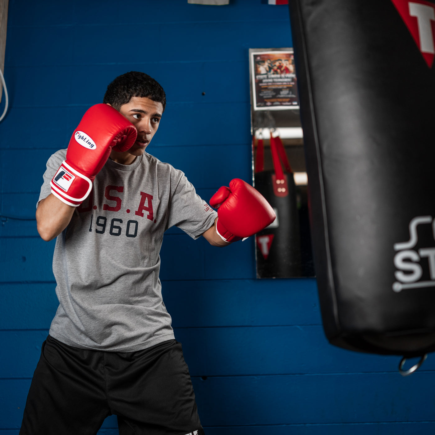 variant:red::Fighting Fury Professional Training Gloves guy wearing gloves hitting punching bag
