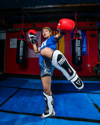 variant:lifestyle::TITLE Boxing Gel Elite Pro Shin & Instep Guards man kicking with shin guards
