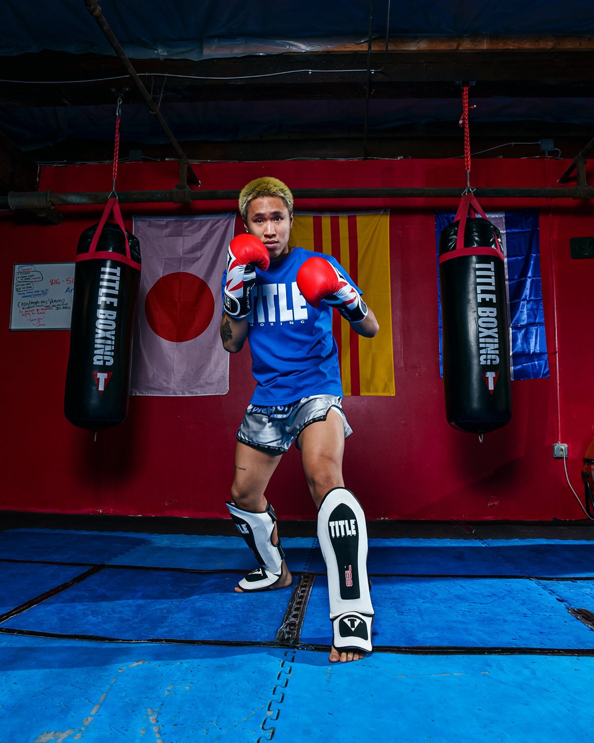 variant:lifestyle::TITLE Boxing Gel Elite Pro Shin & Instep Guards man posing with shin guards