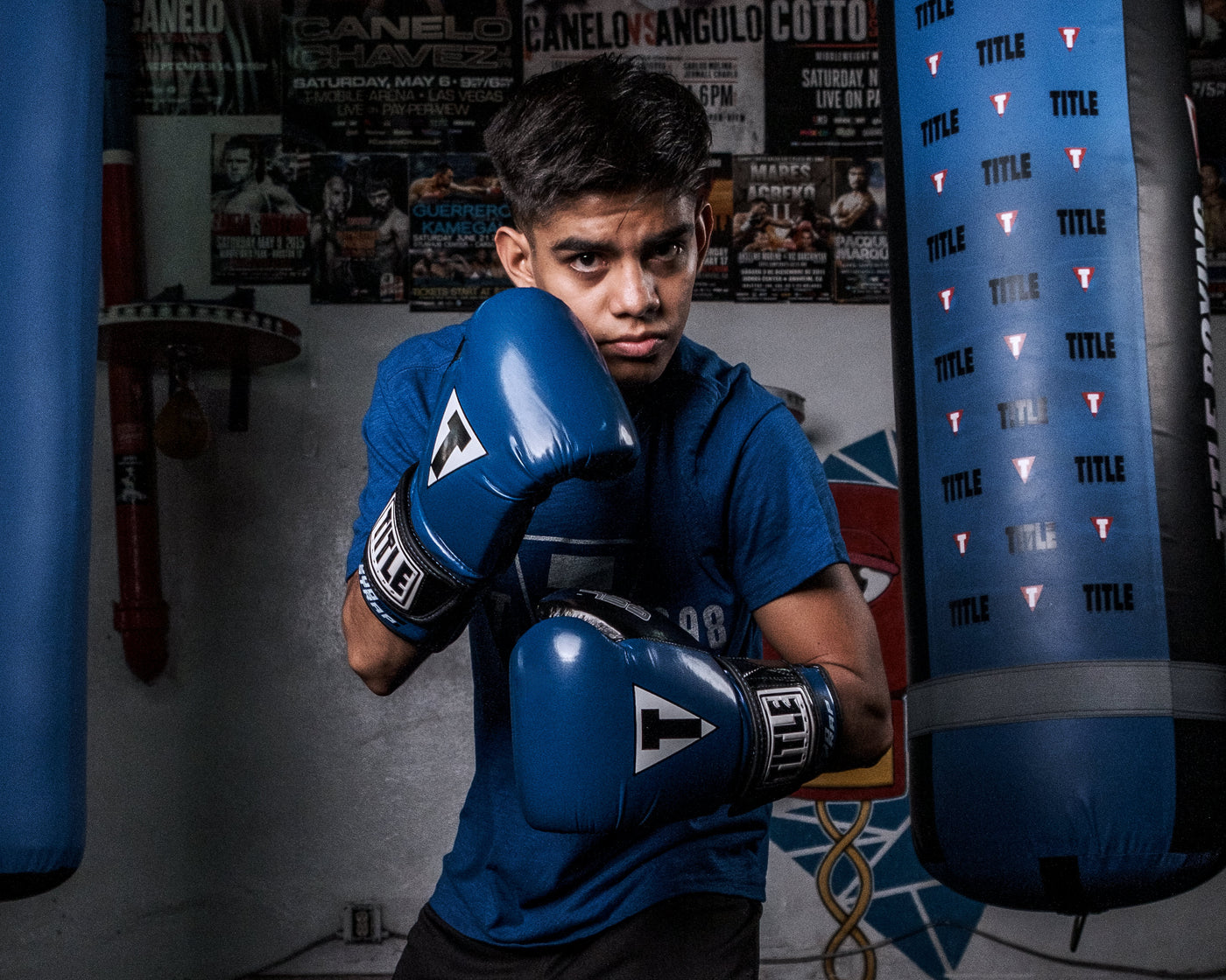 variant:Blue/Black::TITLE Boxing Gel Glory Super Bag Gloves 2.0 boy posing with gloves