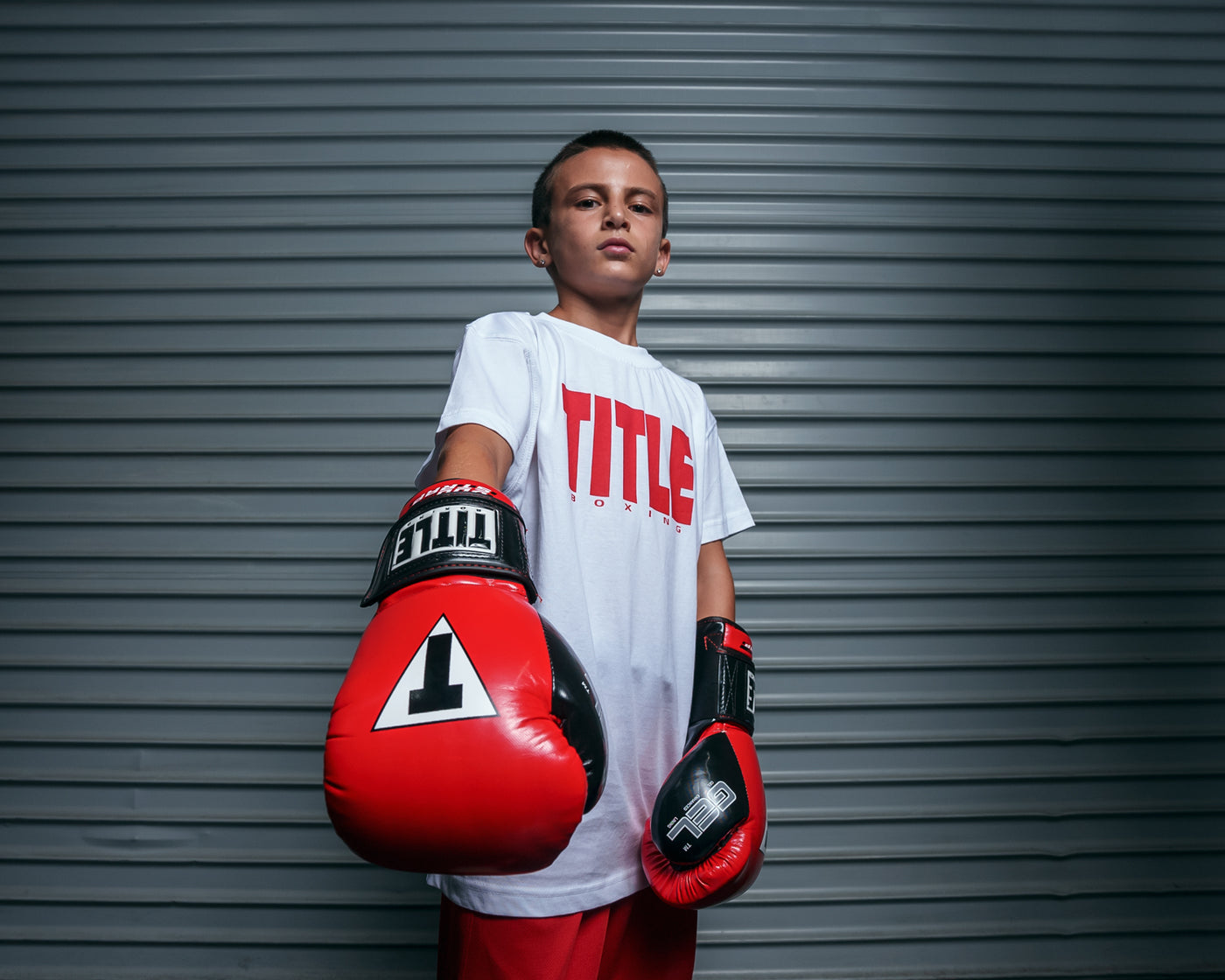 variant:Red/Black::TITLE Boxing Gel Glory Super Bag Gloves 2.0 kid posing with gloves