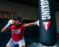 variant:lifestyle::TITLE Boxing Gel World V2T Limited Edition Autism Awareness Bag Gloves guy with boxing gloves hitting punching bag