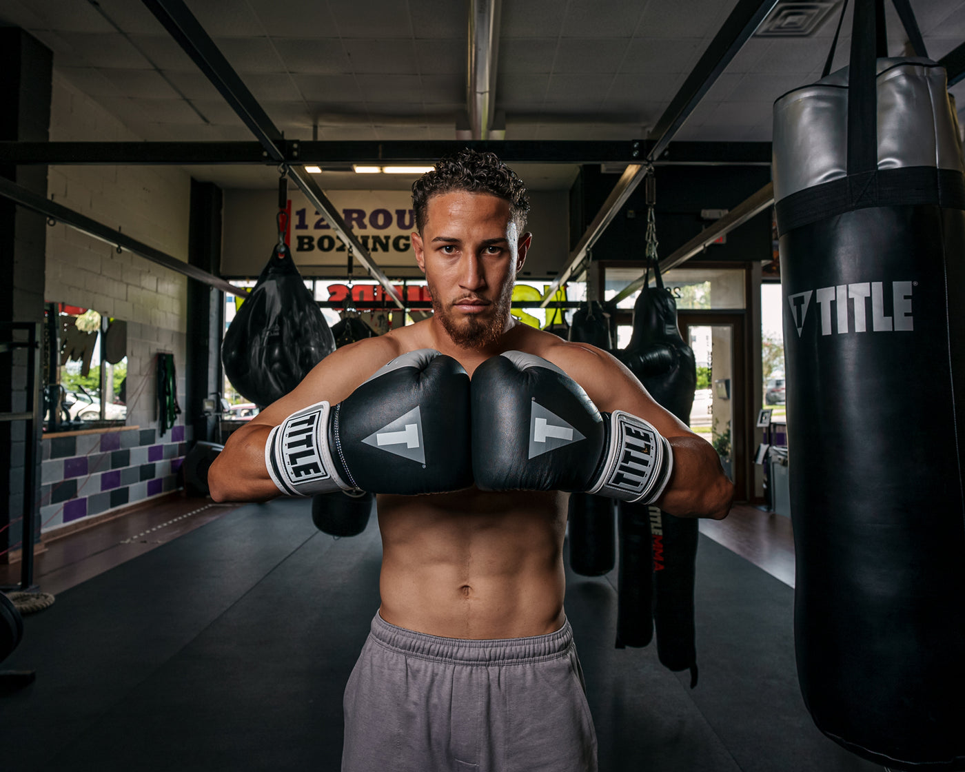variant:black/silver::TITLE Boxing Gel World V2T Bag Gloves guy posing with boxing gloves in boxing gym
