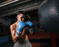 variant:light blue/white::TITLE Boxing Gel World V2T Bag Gloves guy with boxing gloves and heavy bag in gym