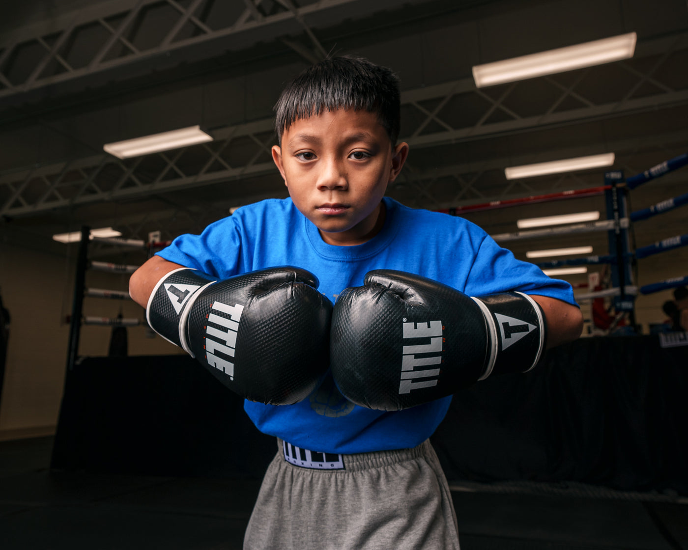variant:black::TITLE Boxing Instinct Fitness Bag Gloves kid posing with boxing gloves
