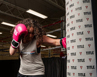 variant:pink/black::TITLE Boxing Instinct Fitness Bag Gloves girl wearing boxing gloves punching heavy bag