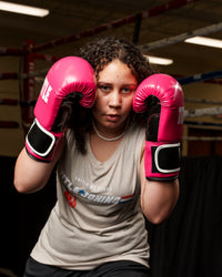 variant:pink/black::TITLE Boxing Instinct Fitness Bag Gloves girl posing with boxing gloves