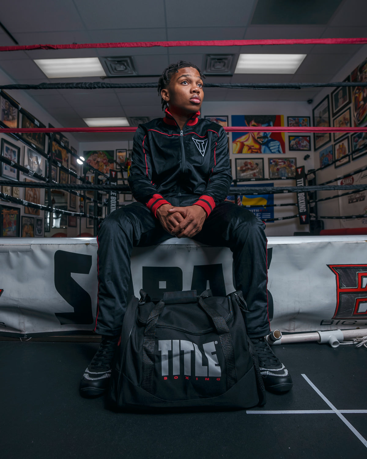 variant:black::TITLE Boxing Individual Sport Bag kid sitting in ring by bag