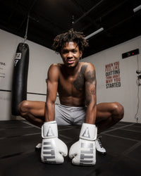 variant:White::TITLE Boxing Inferno Intensity Elastic Training Gloves man posing in gym wearing gloves