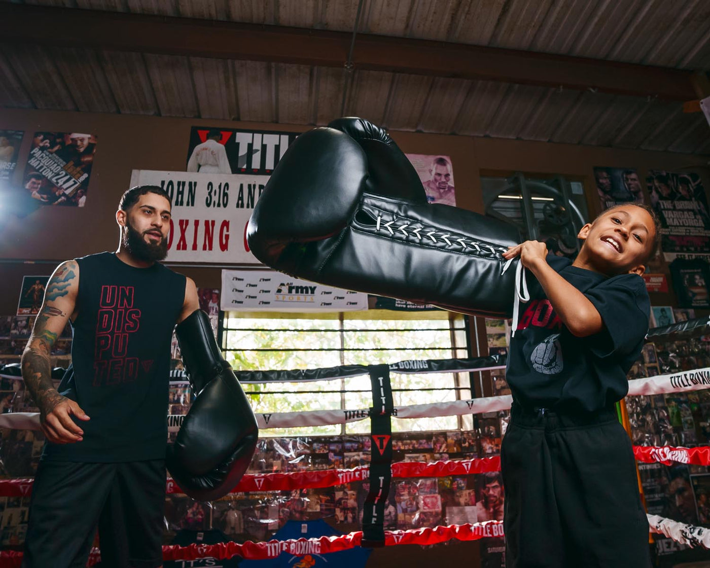 variant:black::TITLE Boxing Jumbo Boxing Gloves 2.0 guy and kid in boxing ring with jumbo boxing gloves