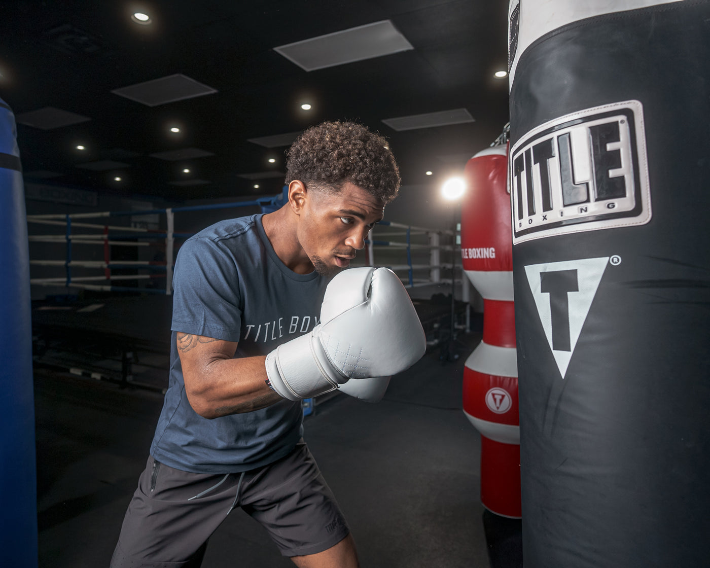 variant:white::TITLE Boxing Ko-Vert Bag Gloves guy wearing boxing gloves boxing with heavy bag