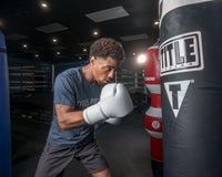 variant:white::TITLE Boxing Ko-Vert Bag Gloves guy wearing boxing gloves boxing with heavy bag
