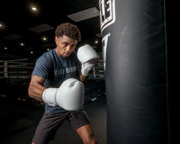 variant:white::TITLE Boxing Ko-Vert Bag Gloves guy wearing boxing gloves boxing with heavy bag