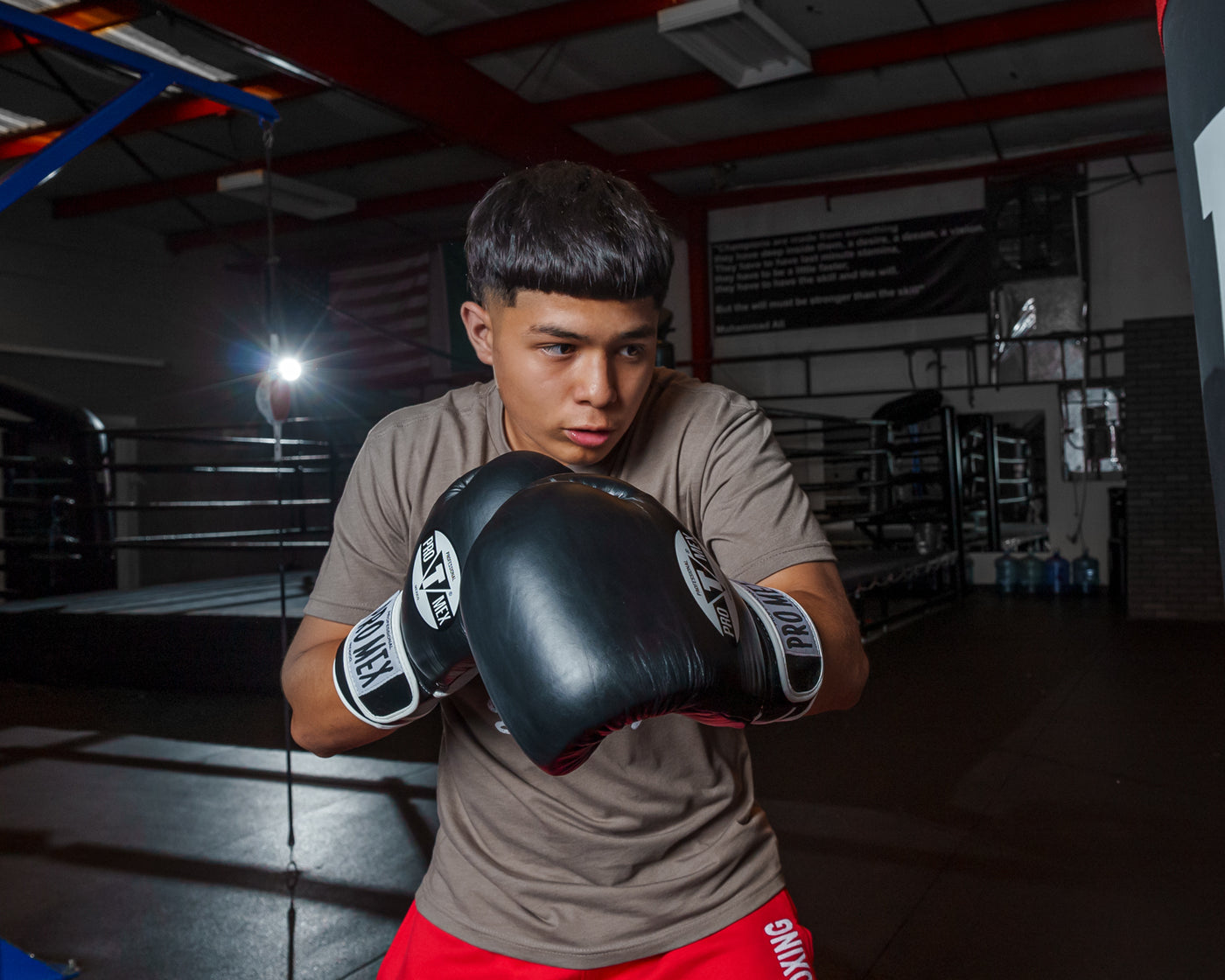 variant:black::Pro Mex Professional Training Gloves 3.0 kid swinging on bag