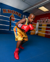 variant:red/white/blue::TITLE Boxing Pro Corner Cushions V3P – Set Of 4 kid wearing boxing gear posing in boxing ring
