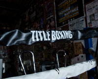 variant:black::TITLE Boxing Pro Vinyl Zippered Rope Cover 4.0 image showing rope cover on boxing ring