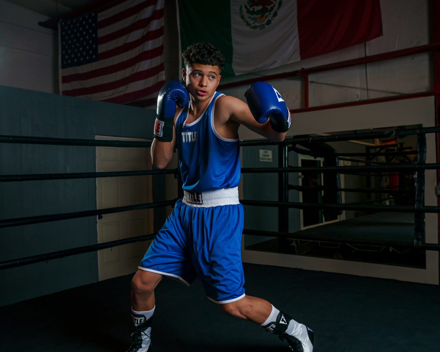 variant:lifestyle::TITLE Boxing Aerovent Elite Amateur Boxing Set 1 2.0 boy in boxing stance blue side