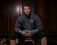 variant:grey::TITLE Boxing Select 180" Semi Elastic Mexican Hand Wraps guy sitting on stool