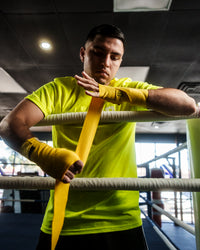 variant:gold::TITLE Boxing Select 180" Semi Elastic Mexican Hand Wraps guy putting on wraps