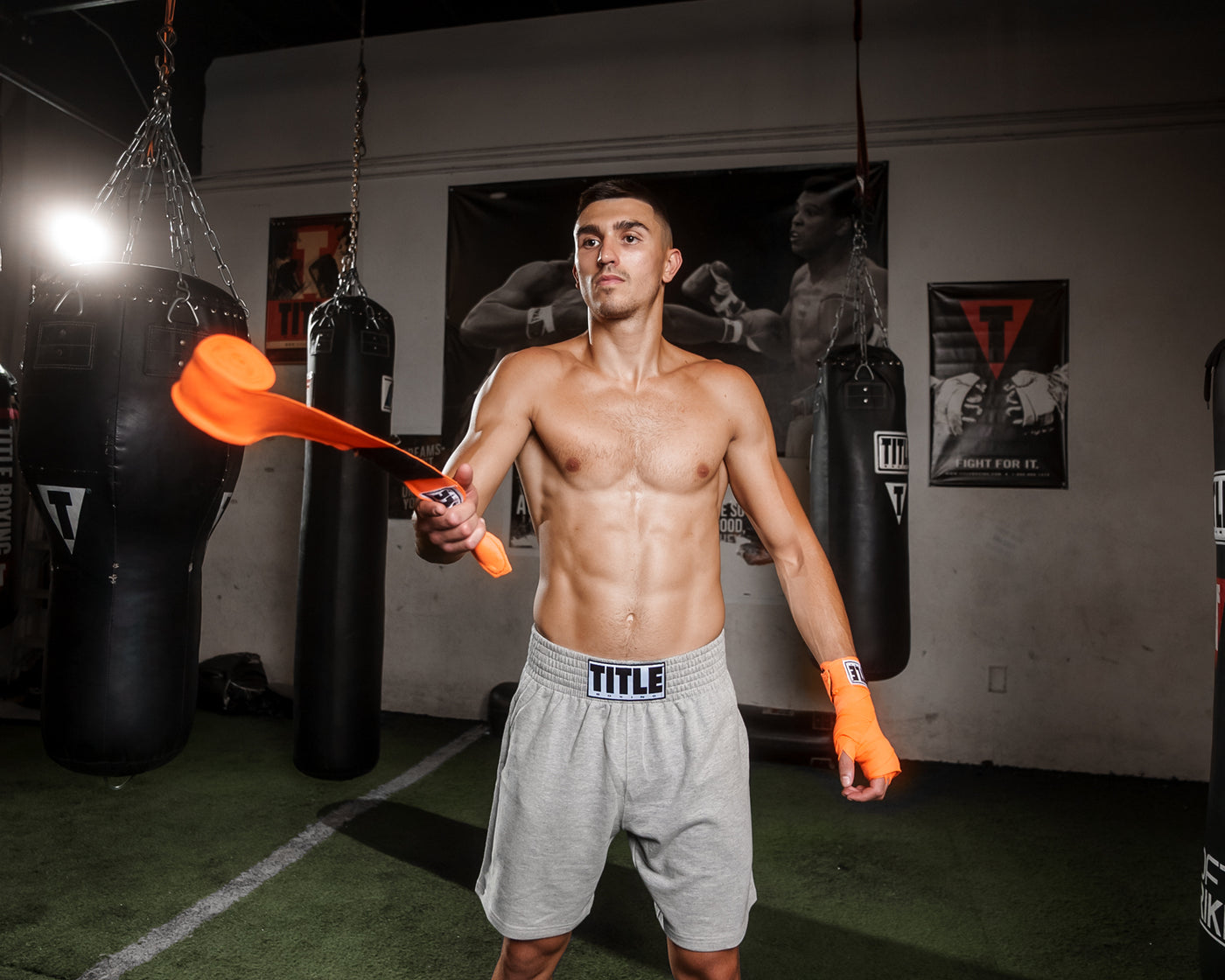 variant:orange::TITLE Boxing Select 180" Semi Elastic Mexican Hand Wraps guy throwing hand wraps out