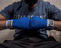 variant:royal::TITLE Boxing Select 180" Semi Elastic Mexican Hand Wraps guy hands together