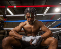 variant:white::TITLE Boxing Select 180" Semi Elastic Mexican Hand Wraps guy sitting outside of ring