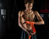 variant:orange::TITLE Boxing Select 180" Semi Elastic Mexican Hand Wraps guy puttin gon wrap 