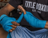 variant:turquoise::TITLE Boxing Select 180" Semi Elastic Mexican Hand Wraps close up on putting on wraps
