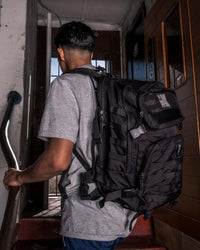 variant:Black::TITLE Boxing Tactical Combat Backpack man posing with backpack