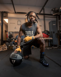 variant:12 lbs::TITLE Boxing Rubber Medicine Ball kid kneeling down with ball