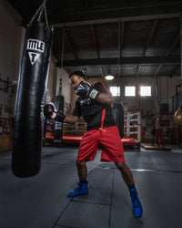variant:Blue/Black::TITLE Boxing Total Balance Shoes man hitting heavy bag