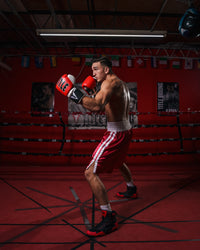 variant:black/red::TITLE Charged Boxing Shoes guy boxing stance view in ring