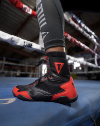 variant:black/red::TITLE Charged Boxing Shoes guy in the ring one foot view
