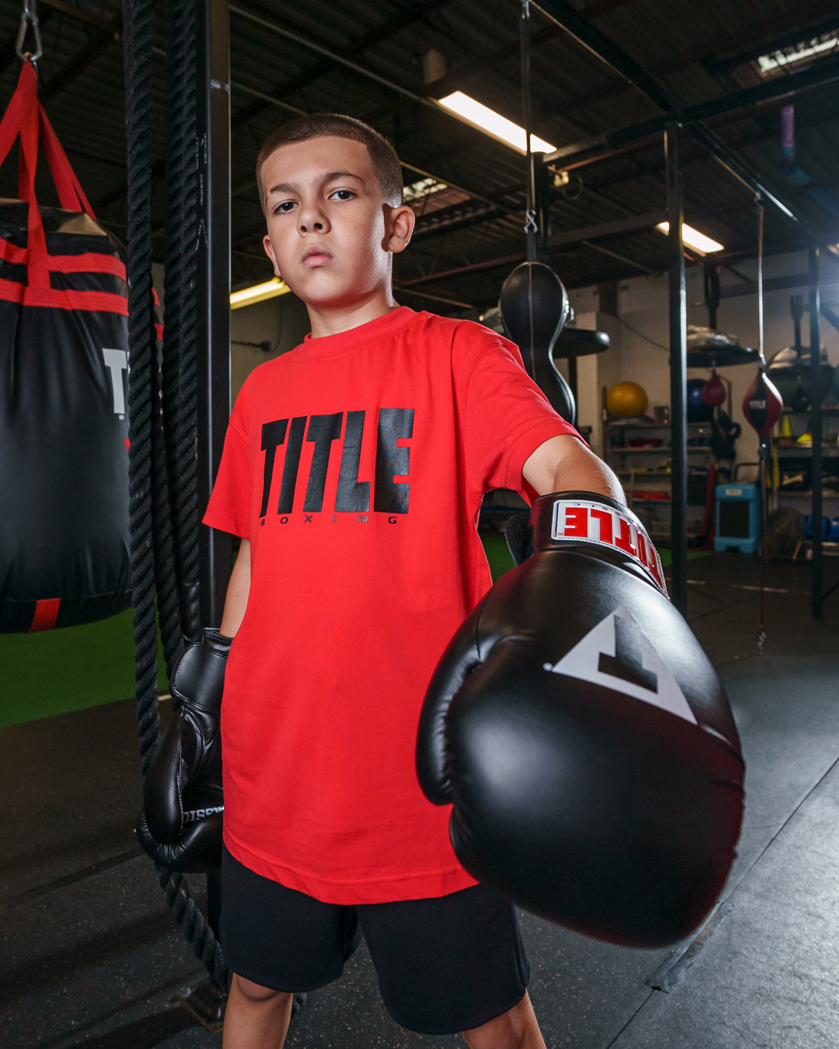 variant:Red/Black::TITLE Boxing Iconic Block Tee kid posing in tee