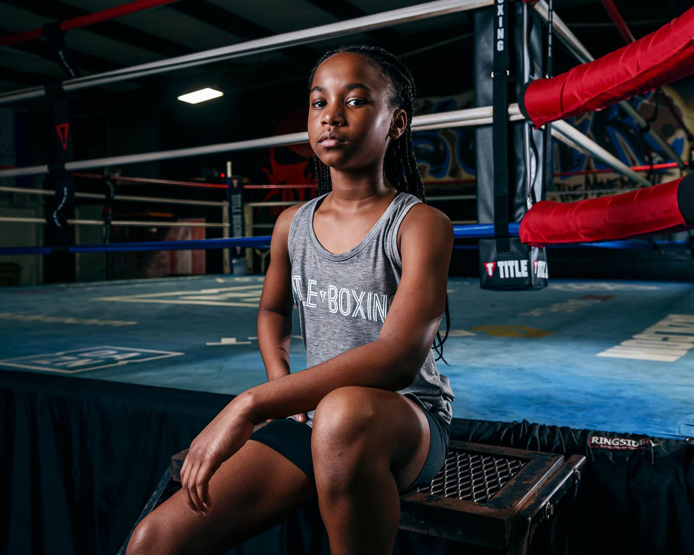 variant:Grey::TITLE Boxing Women's Ogio Luuma Tank girl posing sitting on boxing ring