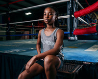 variant:Grey::TITLE Boxing Women's Ogio Luuma Tank girl posing sitting on boxing ring