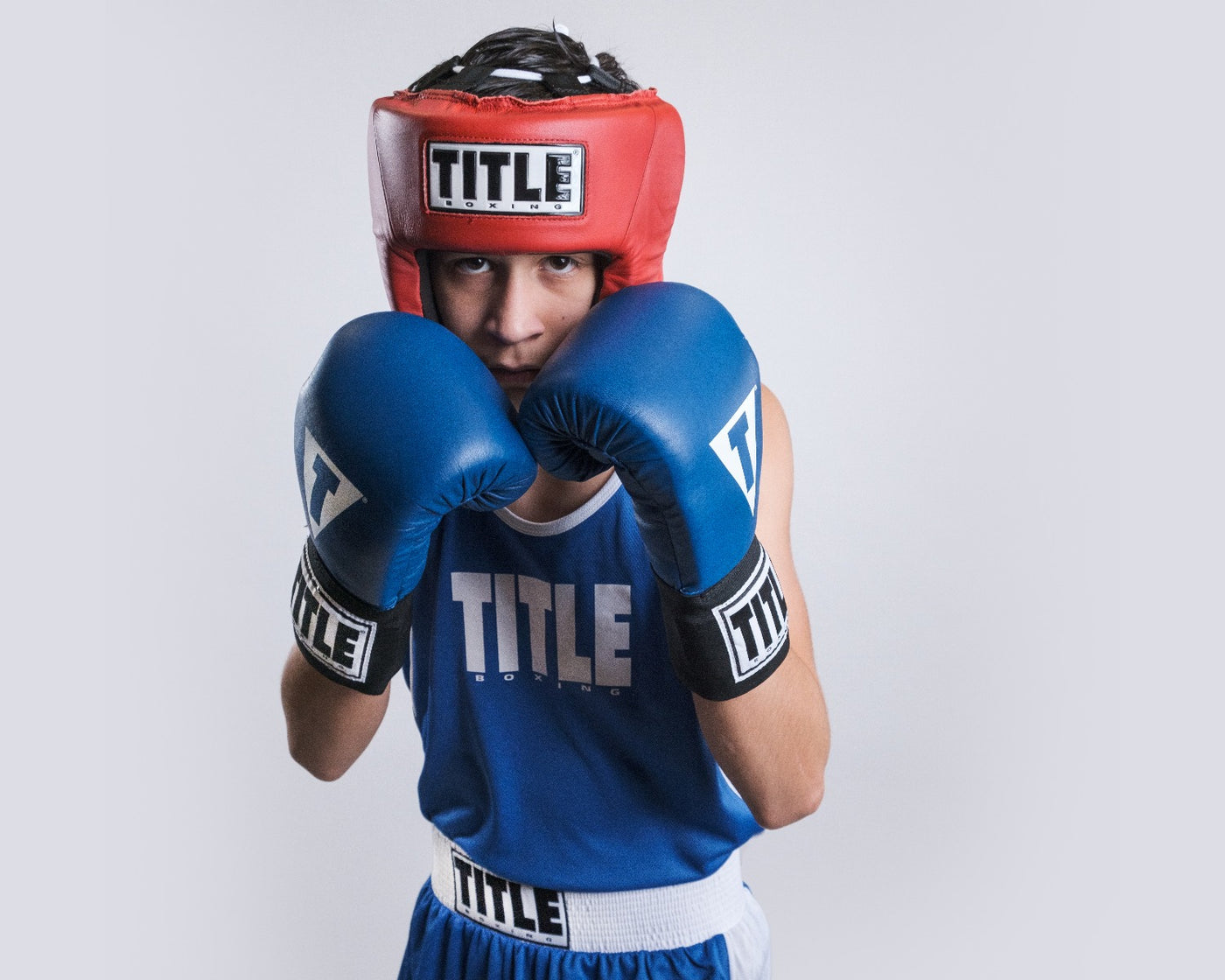 variant:red:TITLE Boxing USA Boxing Competition Headgear - Open Face guy wearing red headgear and blue outfit