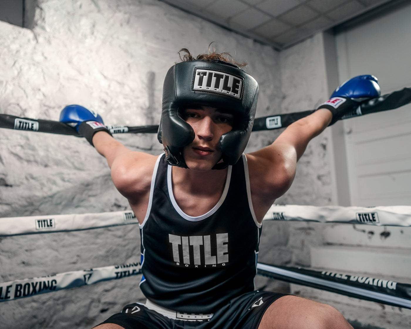 variant:black::TITLE Boxing USA Boxing Competition Headgear - With Cheeks guy hanging from ring rope