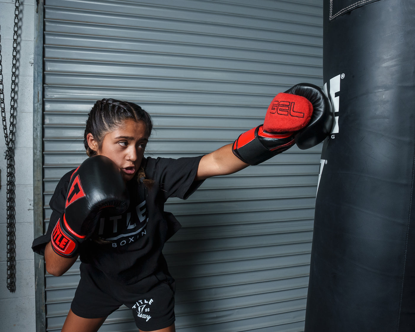 variant:black/red::TITLE Boxing All Heart Bag Gloves 2.0 girl jabbing bag