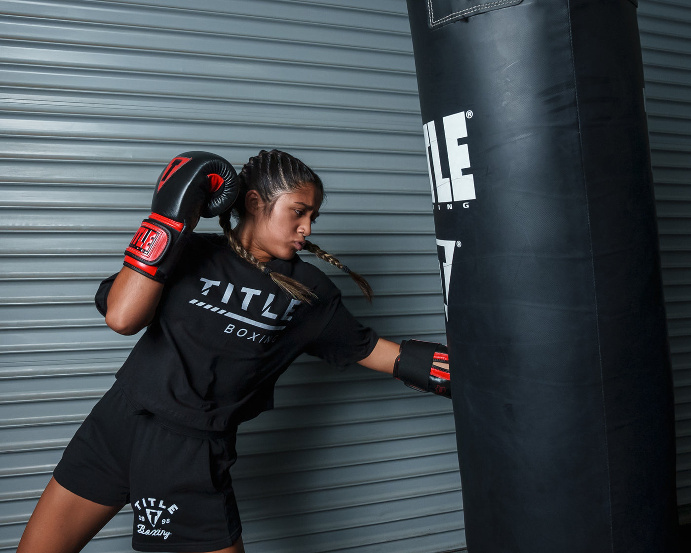 variant:black/red::TITLE Boxing All Heart Bag Gloves 2.0 girl hitting bag