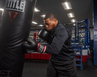 variant:lifestyle::TITLE Boxing Leather Big League Bag Gloves guy hitting a bag