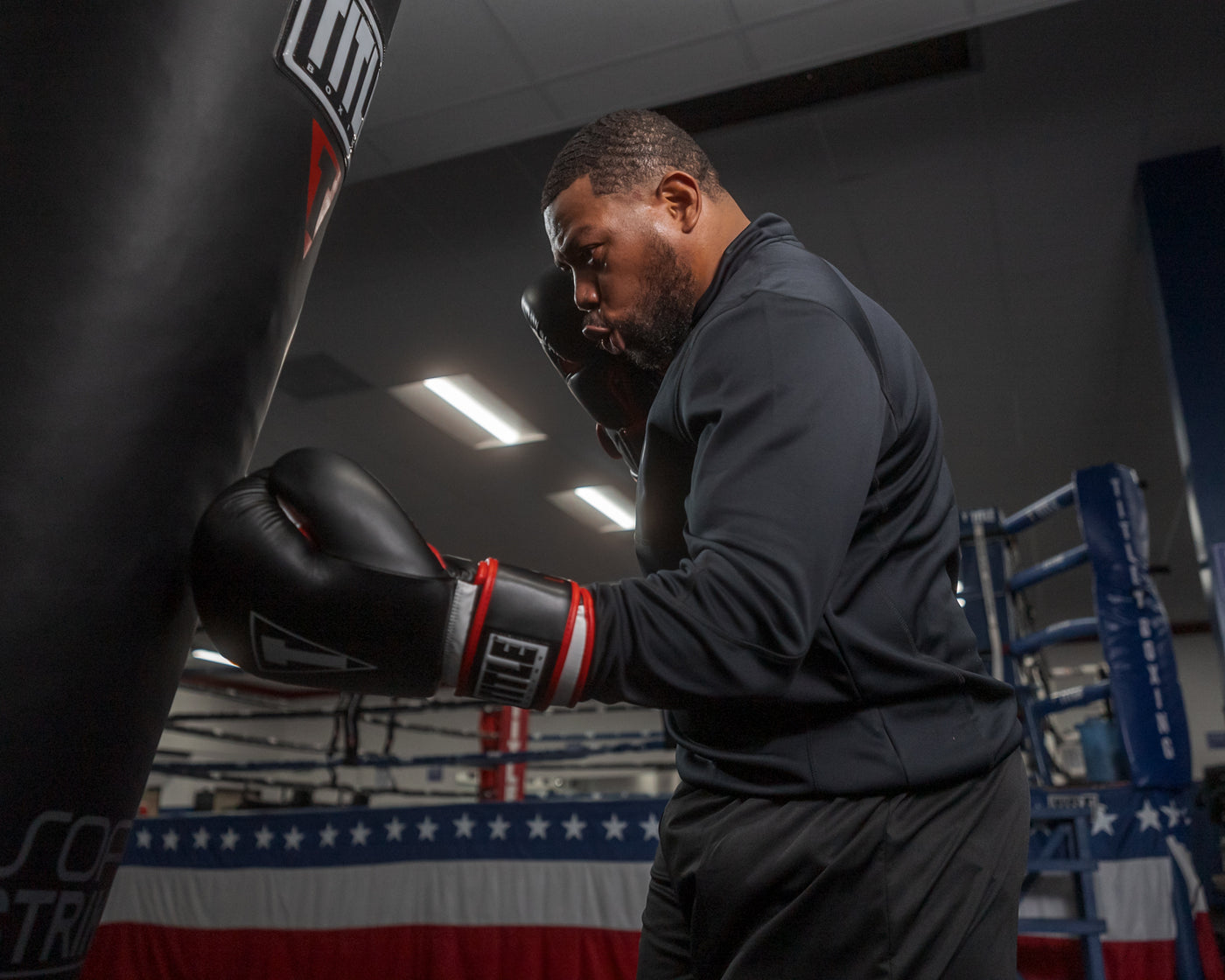 variant:lifestyle::TITLE Boxing Leather Big League Bag Gloves alt version guy hitting bag