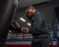 variant:lifestyle::TITLE Boxing Leather Big League Bag Gloves alt version guy hitting bag