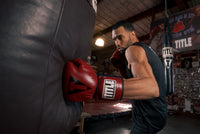variant:lifestyle::TITLE Boxing Blood Red Leather Sparring Gloves guy hitting bag