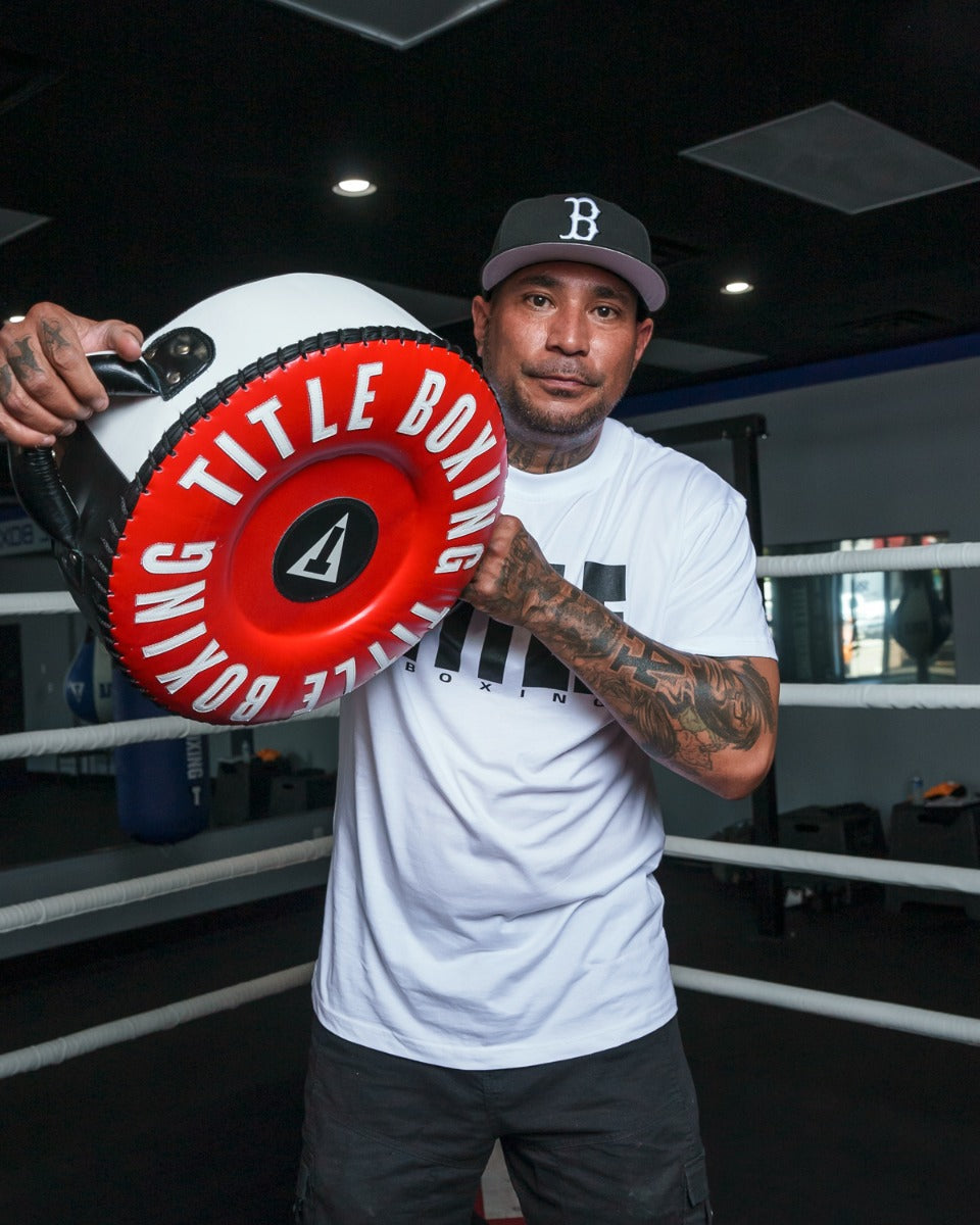 variant:lifestyle::TITLE Boxing Combination Punch Shield coach in r ing with hat on